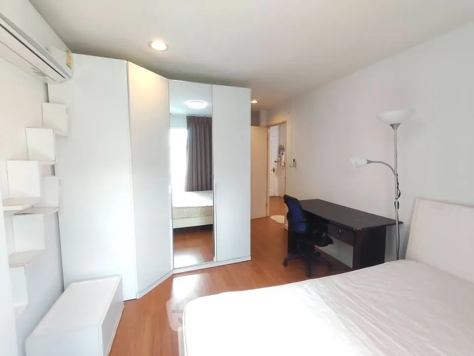 Spacious bedroom with modern furniture and ample natural light in a stylish apartment.