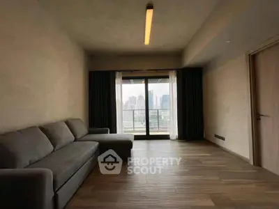 Spacious living room with city view and modern sofa in high-rise apartment.
