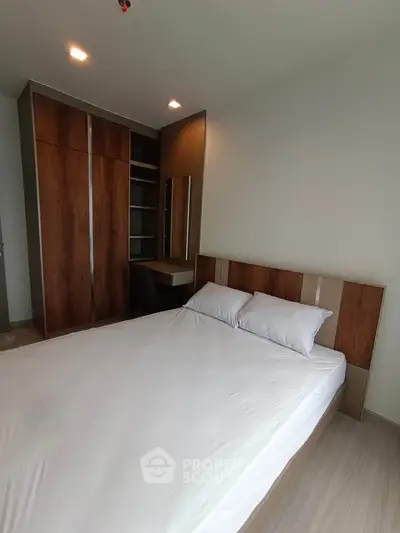 Modern bedroom with sleek wooden wardrobe and cozy bed in a stylish apartment.