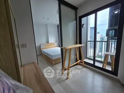 Modern bedroom with city view and balcony access in high-rise apartment