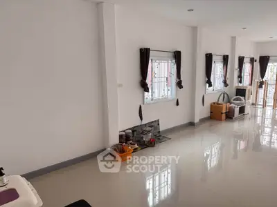 Spacious and bright living room with glossy tiled floors and large windows, perfect for modern living.