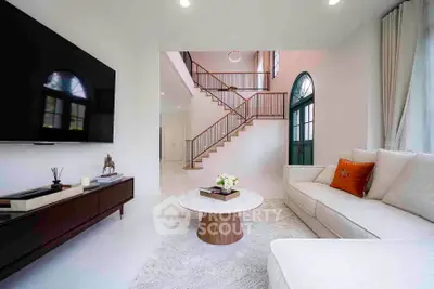 Luxurious living room with modern decor and elegant staircase, perfect for stylish living.