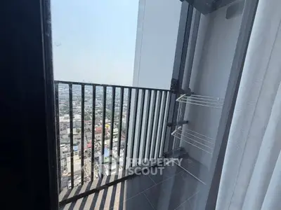 High-rise balcony with stunning city view and drying rack, perfect for urban living.