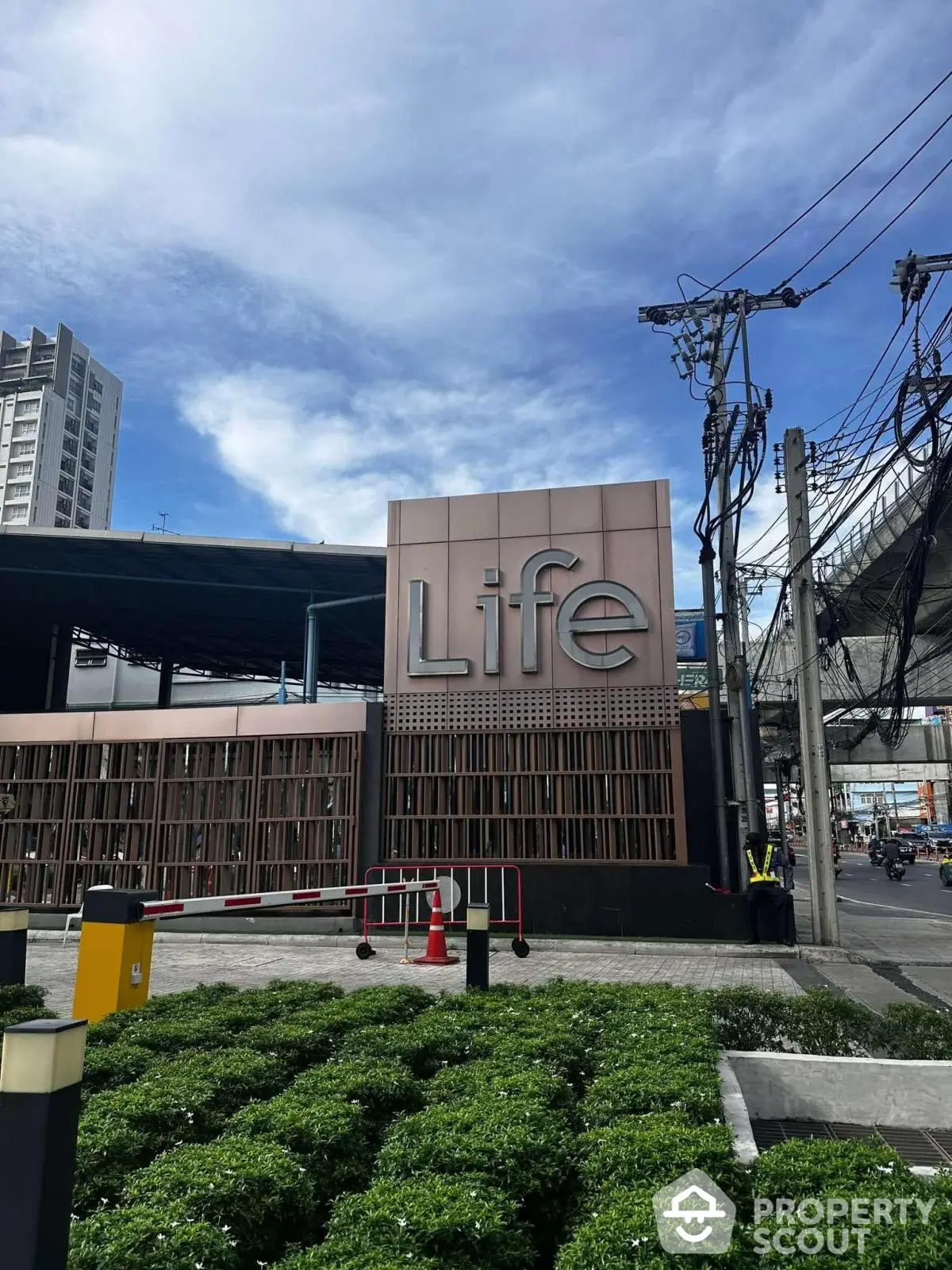 Modern urban building exterior with Life sign and lush greenery