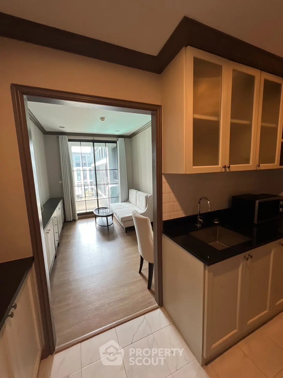 Charming apartment with open kitchen and cozy living room, featuring elegant cabinetry and natural light.