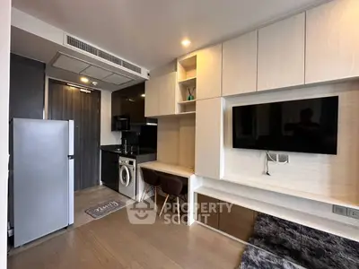 Modern living room with integrated kitchen, featuring sleek cabinetry and built-in appliances.