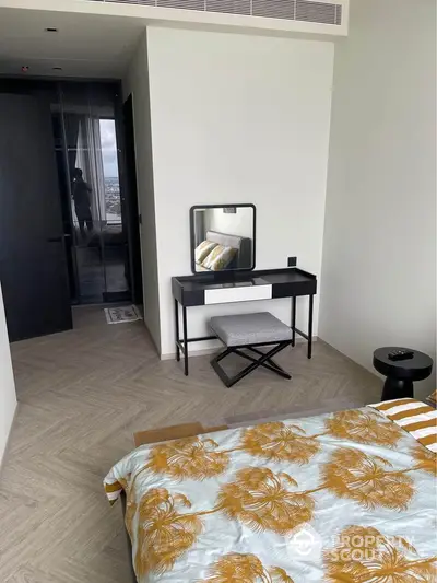 Modern bedroom with stylish decor and city view, featuring a chic vanity and elegant bedding.