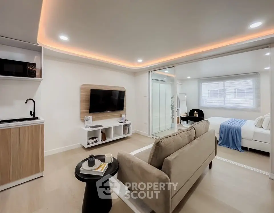 Modern open-concept living room with cozy sofa and sleek kitchenette