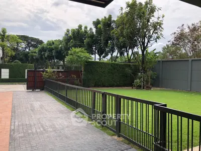 Spacious garden with lush greenery and modern fencing in a serene residential area.