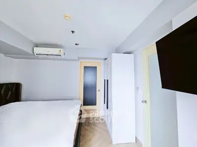 Modern bedroom with minimalist design and wall-mounted TV