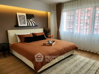 Elegant bedroom with modern decor and large window offering city view