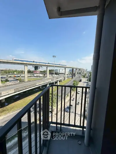 Urban balcony view with highway and skytrain, ideal for city living enthusiasts.