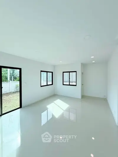 Bright and spacious empty room with large windows and glossy floor tiles, perfect for customization.
