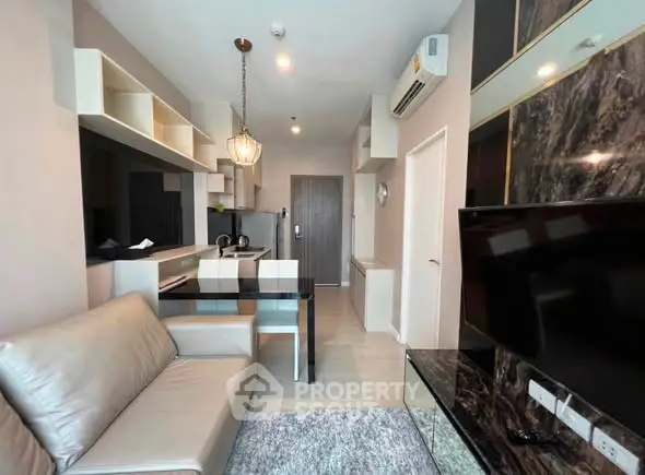 Modern living room with open kitchen, stylish decor, and cozy seating in a contemporary apartment.