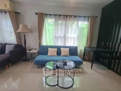 Stylish living room with modern furniture and large windows offering natural light.