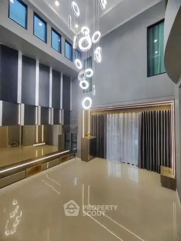 Luxurious modern living room with high ceilings and elegant lighting fixtures.