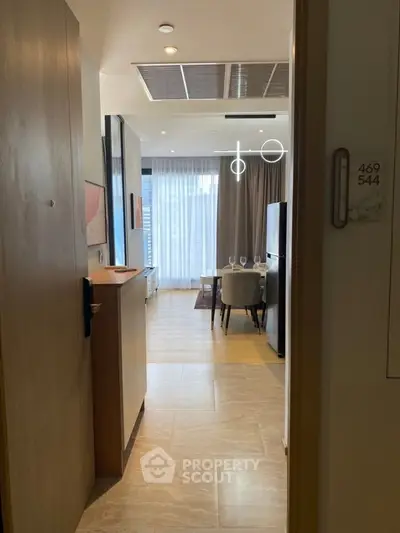 Modern open-plan living and dining area with stylish lighting and large windows in a contemporary apartment.