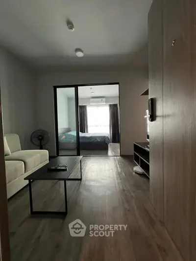 Modern apartment interior with open layout connecting living room and bedroom.