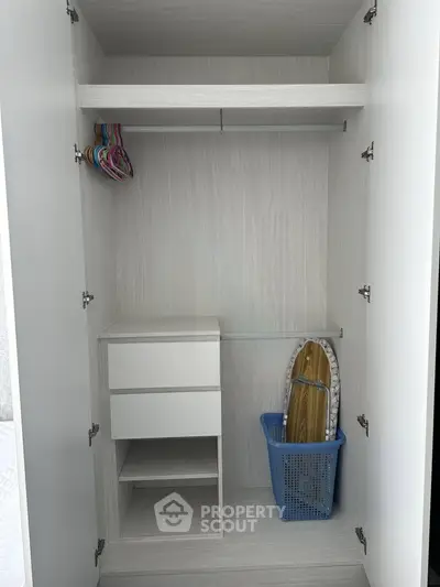 Spacious modern closet with built-in shelves and hanging space, perfect for organized storage.