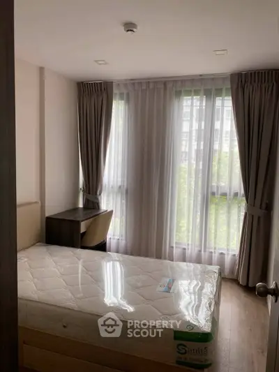 Bright bedroom with large windows and modern furnishings in a stylish apartment.