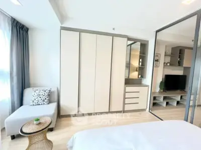 Modern bedroom with sleek wardrobe and cozy seating area, perfect for urban living.