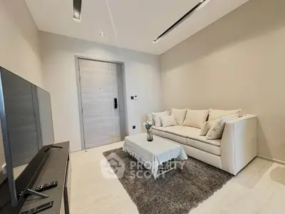 Modern living room with cozy sofa and sleek TV setup in a stylish apartment.