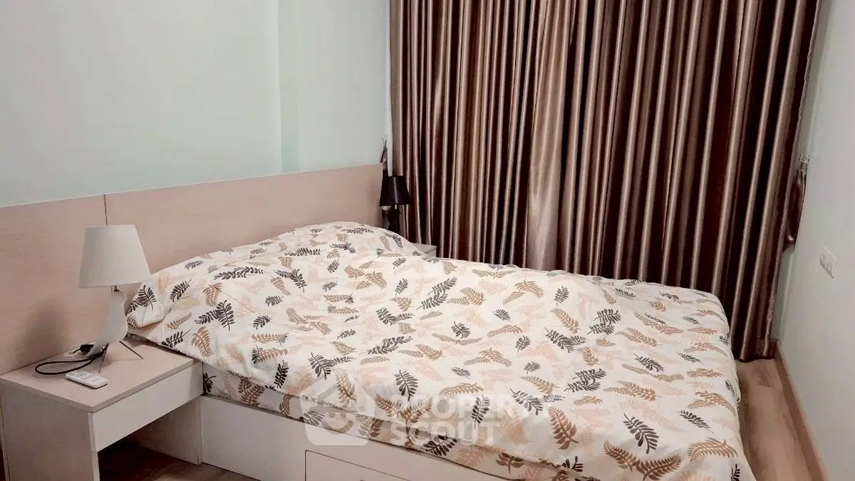 Cozy bedroom with elegant curtains and stylish bedding in modern apartment.