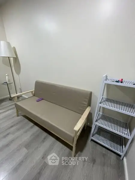 Minimalist living room with beige sofa and modern shelving unit.