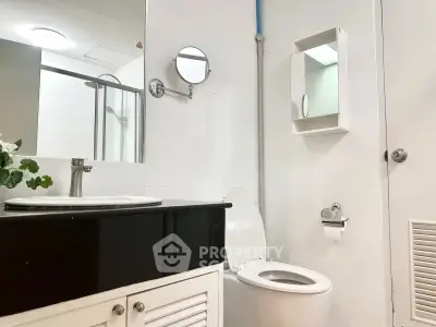 Modern bathroom with sleek fixtures and elegant design, featuring a stylish vanity and contemporary toilet.