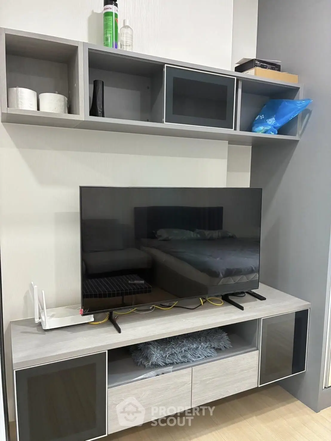 Modern living room with sleek TV stand and wall-mounted shelves, showcasing contemporary interior design.