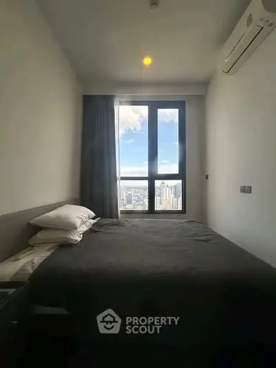 Modern bedroom with city view and air conditioning in high-rise apartment