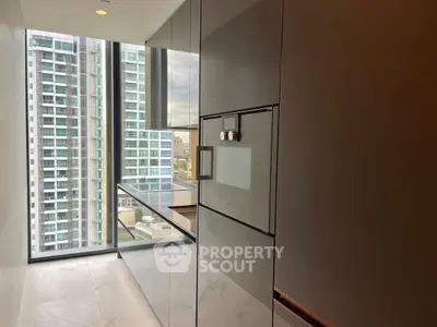 Modern kitchen with sleek cabinetry and city view from large window