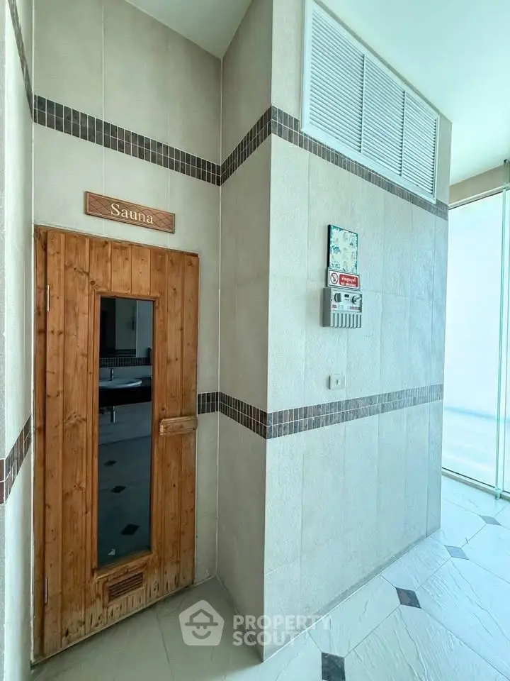 Luxurious sauna entrance in modern building with sleek design and natural wood door.