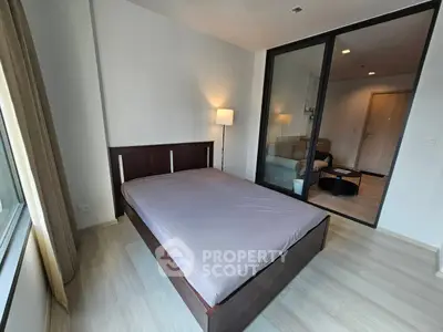 Modern bedroom with glass partition and cozy living area view