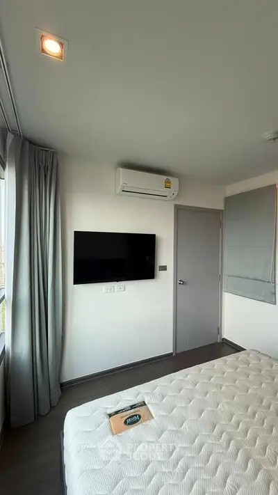 Modern bedroom with air conditioning and wall-mounted TV, featuring a comfortable bed and stylish decor.