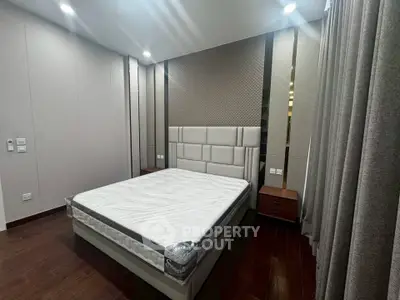 Modern bedroom with stylish headboard and hardwood flooring