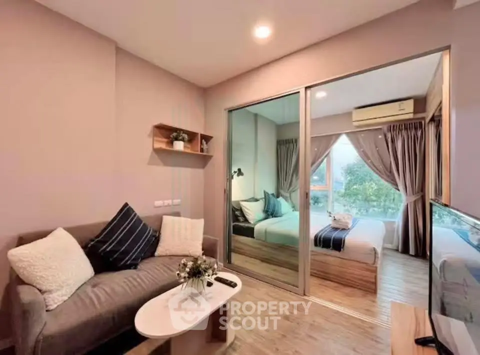 Modern living room with cozy sofa and view into stylish bedroom, featuring elegant decor and natural light.