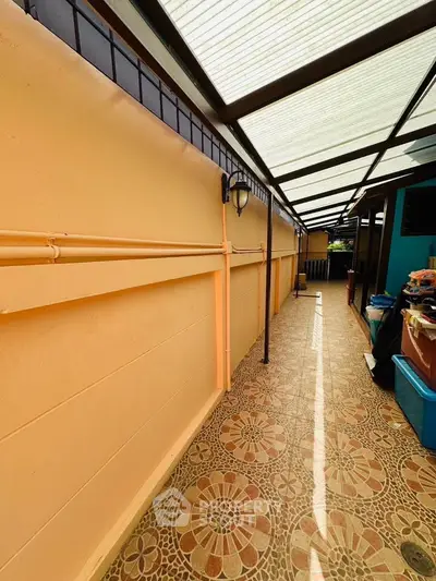 Charming covered outdoor corridor with decorative tiles and warm lighting, perfect for relaxation.