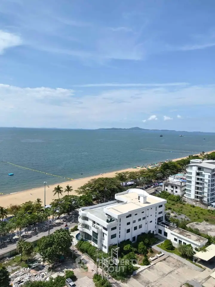 Stunning beachfront view from high-rise apartment overlooking serene ocean and sandy beach.