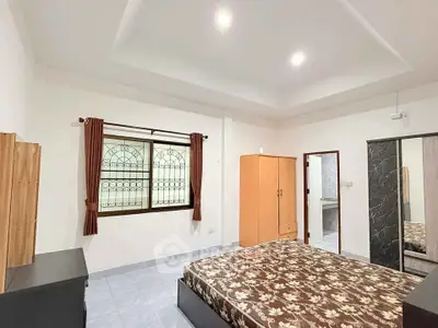 Spacious bedroom with elegant ceiling design and ample natural light