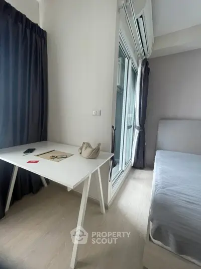 Modern bedroom with sleek design, featuring a minimalist desk and large window for natural light.
