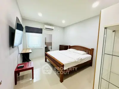 Spacious bedroom with modern furnishings and natural light, perfect for comfort and relaxation.