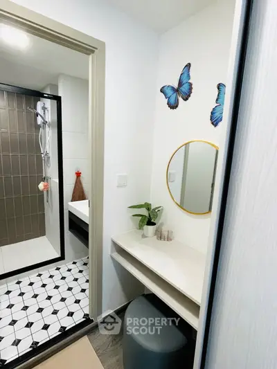 Modern bathroom with stylish decor and vanity area, featuring butterfly wall art and sleek shower design.