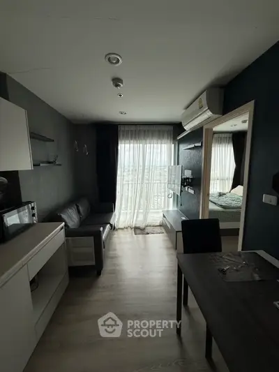 Modern living room with sleek furniture and large window offering city view