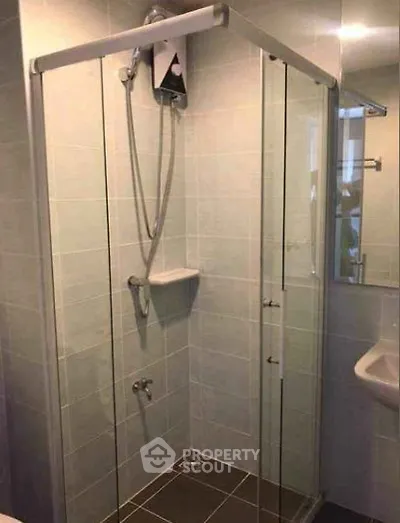 Modern bathroom with glass shower enclosure and sleek tile design.