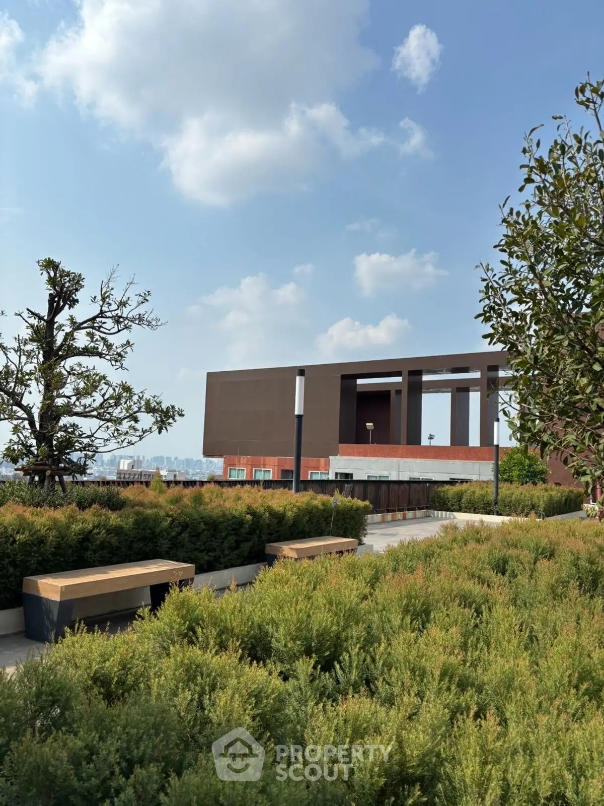 Modern rooftop garden with lush greenery and city views, perfect for relaxation and leisure.