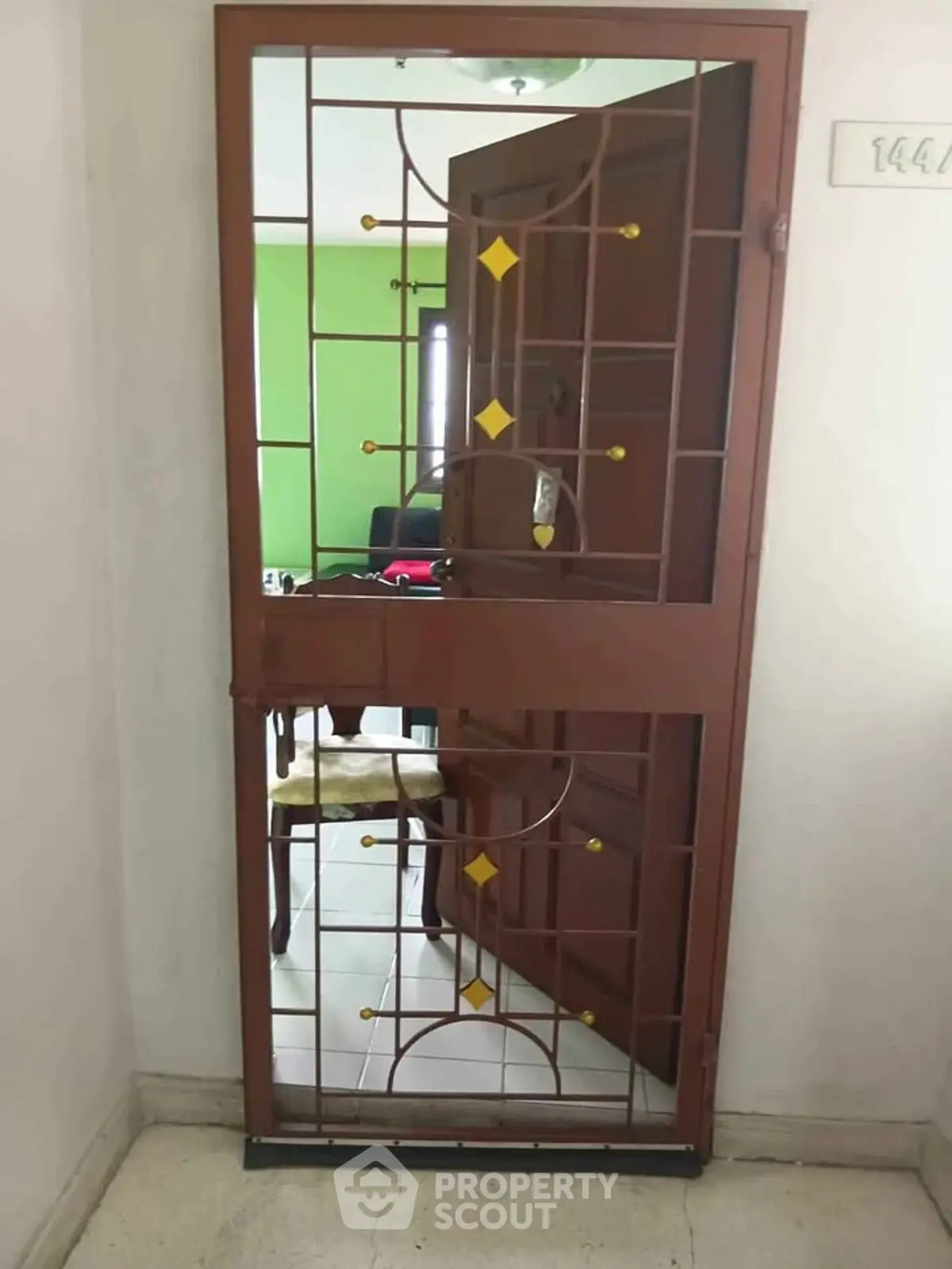 Stylish entrance door with decorative metal grill in modern apartment building.