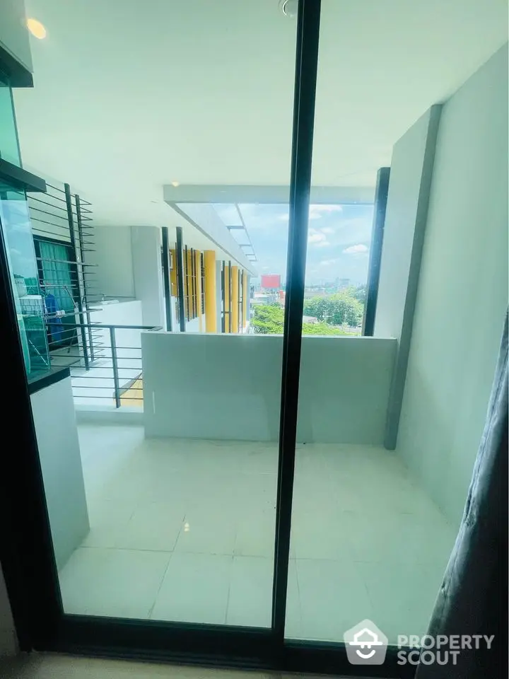 Modern apartment balcony with city view and glass railing