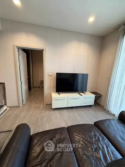 Modern living room with sleek leather sofa and flat-screen TV, perfect for relaxation and entertainment.