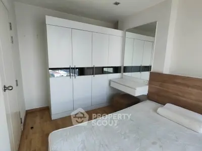 Spacious bedroom with modern wardrobe and wooden flooring